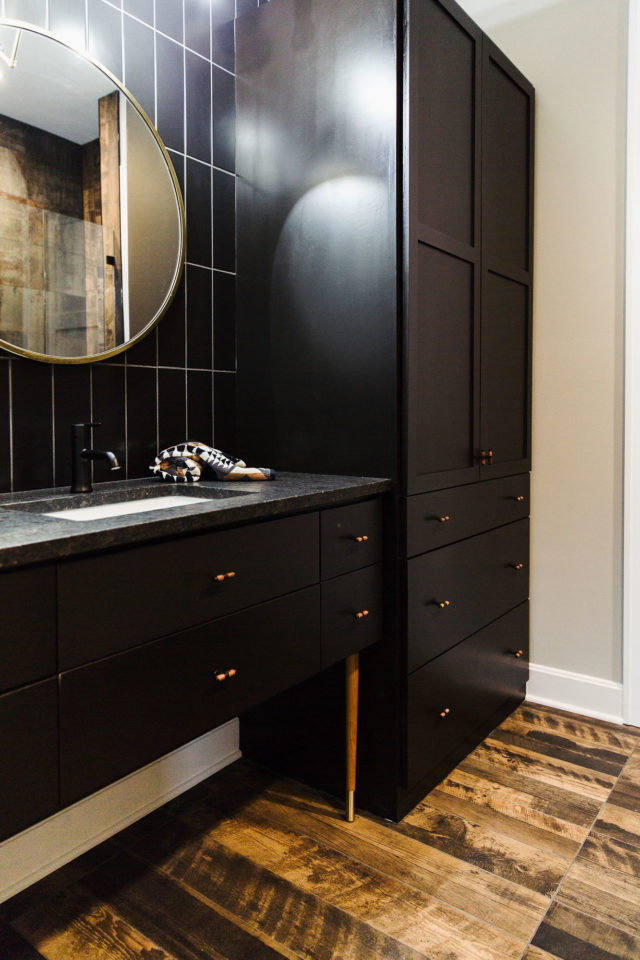 bathroom with black vanity and stone countertops